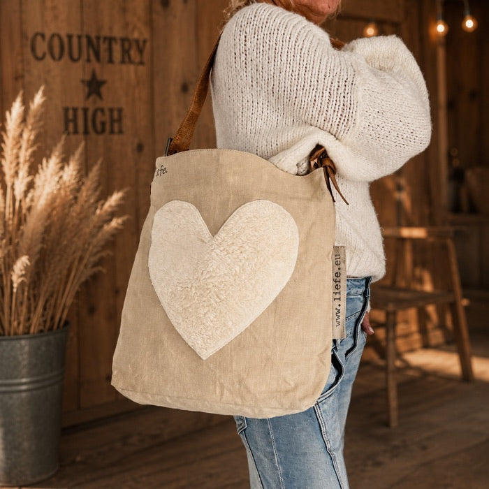 Canvas-Bag mit Herz vor der COUNTRY HIGH Holzwand getragen